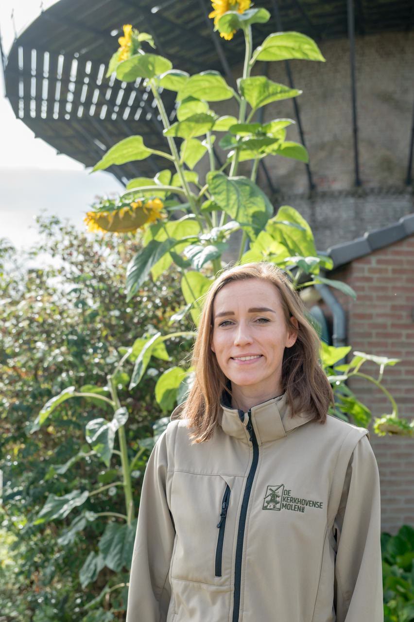 Irisa Derks bij de Kerkhovense Molen, met zonnebloemen op de achtergrond